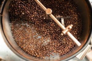 granos de café tostados en una máquina de refrigeración foto