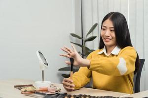 Young Asian beauty blogger is showcasing cosmetic products as well as tutorials on how to apply and record makeup tutorials on social media networks. photo