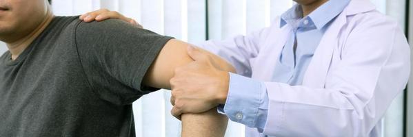 los fisioterapeutas presionan el hombro del paciente para comprobar si hay dolor.