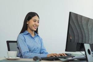 Business woman working on desktop computer monitor professional and sitting at her office desk and working on new software program. photo