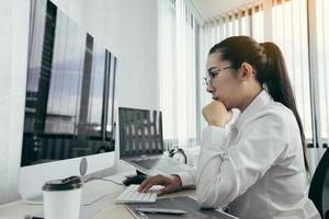Asian female software developer is worried about analyzing code-based systems at his office.