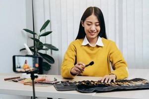 Young Asian beauty blogger is showcasing cosmetic products as well as tutorials on how to apply and record makeup tutorials on social media networks. photo