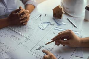 The partnership engineering man or co-workers working on a project and discussing together with looking at blueprint paperwork. photo