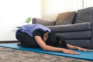 las mujeres asiáticas hacen ejercicios de estiramiento después de tomar clases de yoga en casa. foto