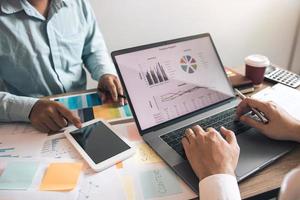 Two business partnership coworkers discussing a financial planning graph and company during a budget meeting in office room. photo