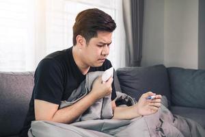 Asian people feel stressed because having cough and cold and using a thermometer to check if he has fever or illness at his home. photo