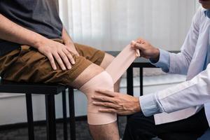 fisioterapeutas asiáticos están examinando los resultados de la cirugía de rodilla.