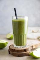 Green apple banana smoothie in glass with paper straw. Healthy lifestyle, dieting and detox.