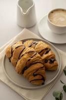 croissants con taza de chocolate y café sobre fondo brillante. hora del desayuno