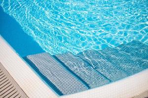 superficie de agua ondulada de la piscina. agua rasgada azul en la piscina banner de vacaciones de verano, actividad recreativa de relajación al aire libre foto