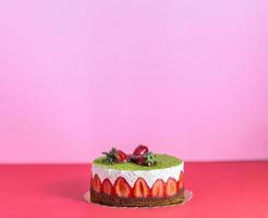 Strawberry and pistachio pie over isolated colorful background with minimal looking. Copy space includes. photo