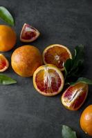 Bloody oranges slices with fresh leaves. Abstract citrus fruit background, horiyontal with copy space. photo
