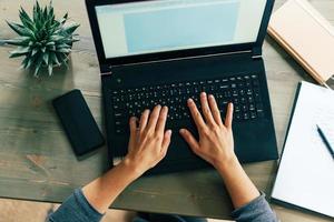 hands on laptop keyboard photo
