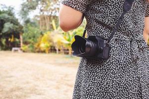 estilo de vida vintage mujer joven fotógrafo mujer joven sosteniendo una lente de cámara. foto