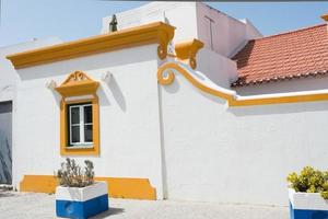 Picturesque town in Alentejo, Portugal. Vila Nova de Milfontes. White building with yellow decoration. photo