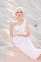 blonde woman in the desert with goldfish in her hands photo