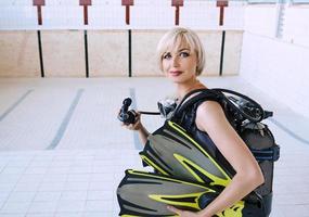 young blonde woman with diving equipment in empty swimming pool. Education, hobby concept photo