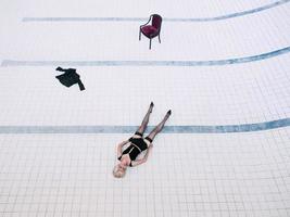 young woman in black underwear and stockings alone in the empty swimming pool photo