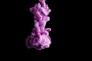 gota de tinta de color púrpura en el agua, tinta arremolinándose. imagen de abstracción para referencia de fondo o color. foto
