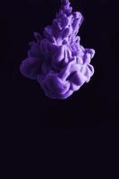 Purple ink drop in clear water and black background. abstract image for background or color reference. photo