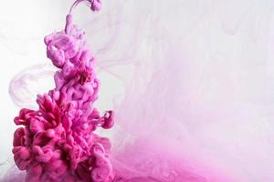 gota de tinta de color rosa en el agua, tinta arremolinándose. imagen de abstracción para referencia de fondo o color. foto