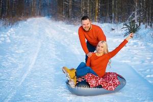 happy guy and girl riding in the snow photo