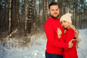 the couple in the red sweater in the winter in the forest happy hug romance