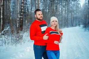 Young Couple Embracing in Winter Forest. Winter Vacations photo