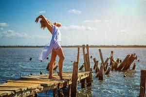 hermosa chica posando en el muelle en un día soleado de verano foto