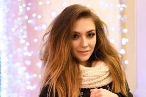 Portrait of a happy young woman on the street with a garland background photo