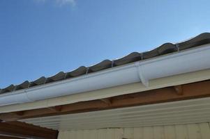 Icicles of ice hang on the structure of the roof of the house photo