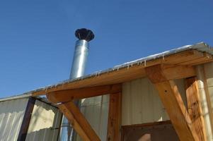 Icicles of ice hang on the structure of the roof of the house photo