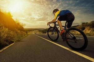 hombre asiático montando una bicicleta en una carretera abierta. foto