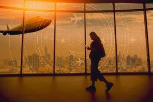 A young tourist walks past a simulated screen showing various flights. for transport and passengers photo