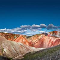 Beautiful Icelandic landscape of colorful rainbow volcanic Landmannalaugar mountains, famous Laugavegur hiking trail with blue sky and red volcanic soil in Iceland, gradient copy space background. photo