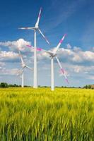 View over beautiful green farm landscape with light and shadow waves in Germany with clouds in sky, and wind turbines to generate electrical power. photo