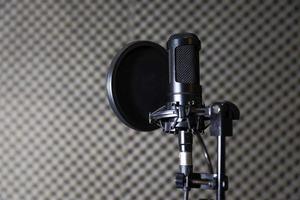 Microphones, condenser mic and mic stand with a recording studio background photo
