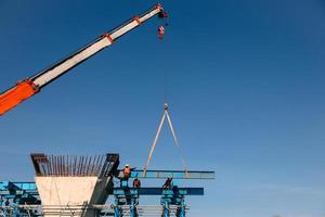 Industrial Crane lifting steel frame in mega construction site of fly over project photo