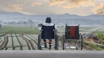 mulher idosa com cadeira de rodas vazia juntos