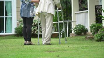 Elderly woman exercise walking in backyard with daughter