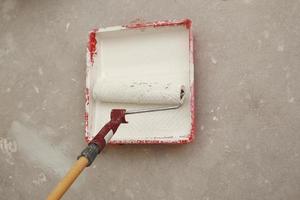 Cropped-image of a builder using paint roller in his work indoors photo