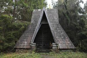 old wooden house in autumn forest lake in Carpathians photo