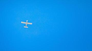 un pequeño avión ligero vuela en el cielo despejado. vista desde abajo. orientación horizontal. foto