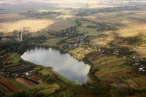 Aerial view of farmland area landscape and lake from airplane. Landscape with lake. Environment protection. Drone flight. view of the village from the sky. photo with noise