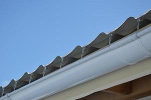 Icicles of ice hang on the structure of the roof of the house photo