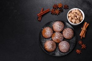 Beautiful delicious cupcakes with cocoa and raisins on a black concrete background photo