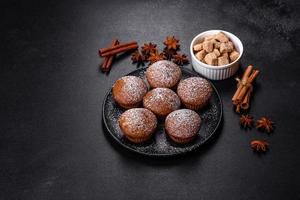 Beautiful delicious cupcakes with cocoa and raisins on a black concrete background photo