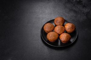 Beautiful delicious cupcakes with cocoa and raisins on a black concrete background photo