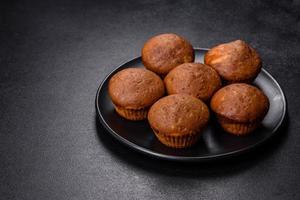 Beautiful delicious cupcakes with cocoa and raisins on a black concrete background photo