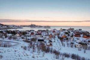 Colorful Norwegian village with snow covered on coastline in winter at boundary of Lofoten islands
